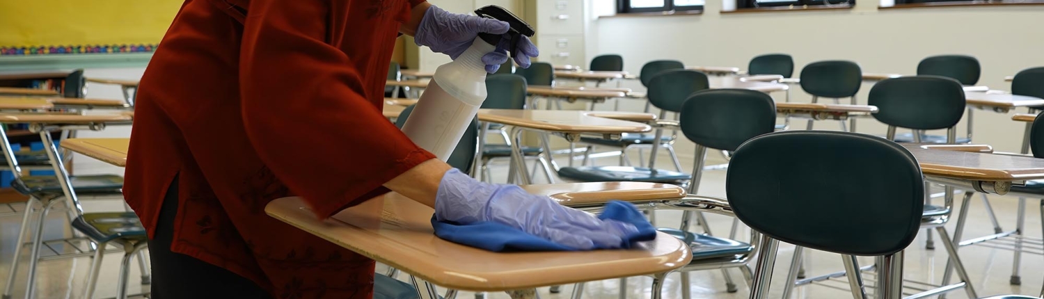Side view of a woman cleaning desks