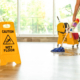 Safety sign with phrase Caution wet floor and cleaner indoors