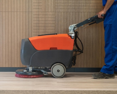 Worker using machine to clean floor