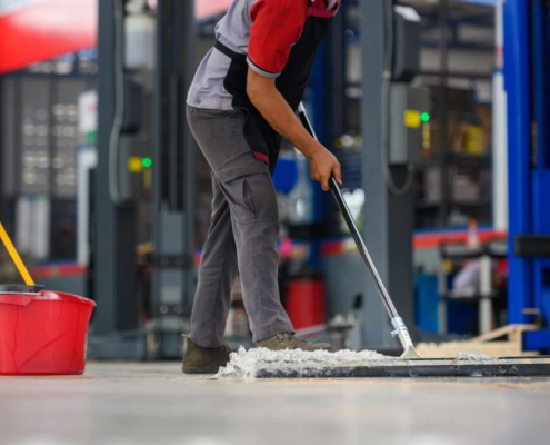 Worker cleaning warehouse
